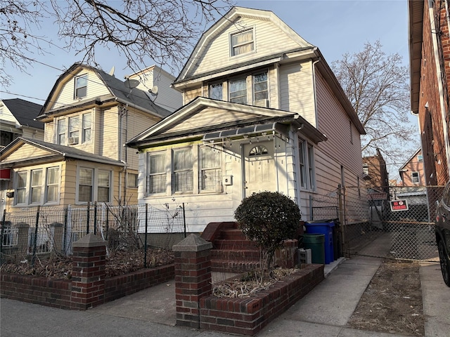 view of front of property featuring fence and a gambrel roof