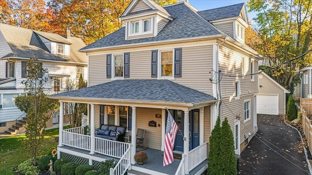 view of front of property featuring a porch, a shingled roof, and aphalt driveway