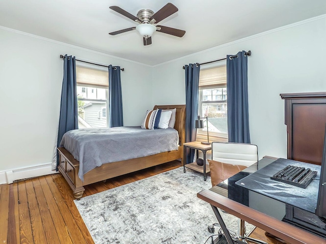 bedroom featuring crown molding, baseboard heating, ceiling fan, wood finished floors, and baseboards