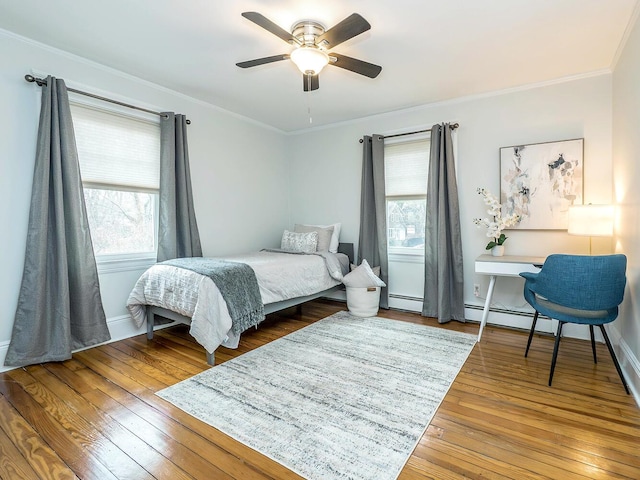 bedroom featuring ornamental molding, multiple windows, wood-type flooring, and baseboards