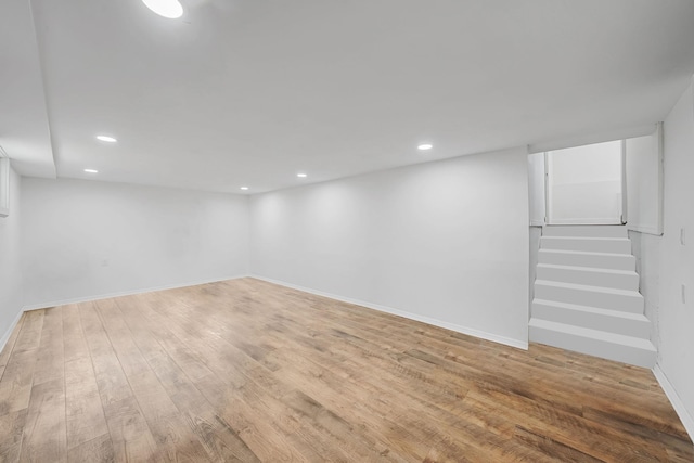 finished below grade area featuring baseboards, light wood-style flooring, and recessed lighting