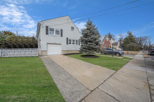 view of side of home with a yard, fence, driveway, and an attached garage