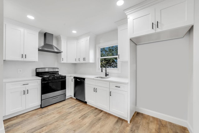 kitchen featuring black dishwasher, wall chimney exhaust hood, light countertops, stainless steel range with gas cooktop, and a sink