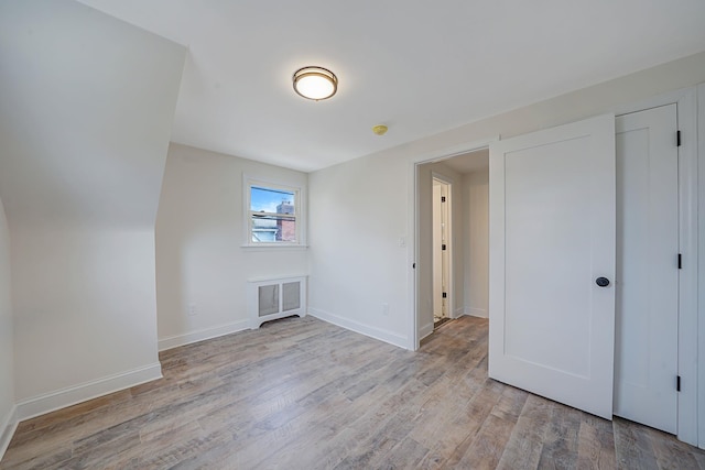 additional living space with light wood-type flooring, visible vents, and baseboards