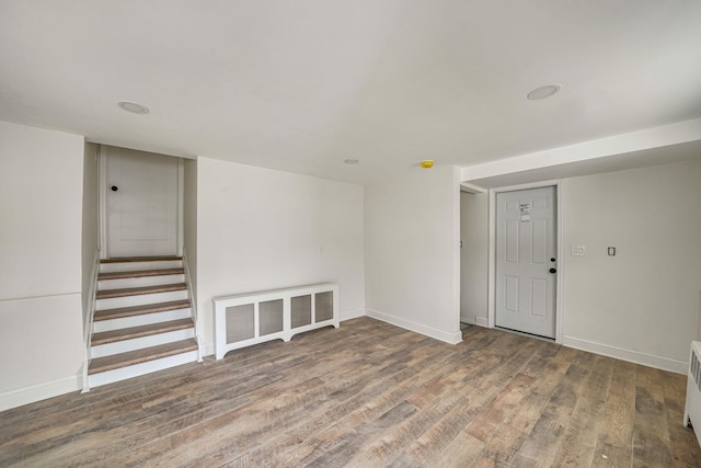 empty room featuring stairway, baseboards, and wood finished floors