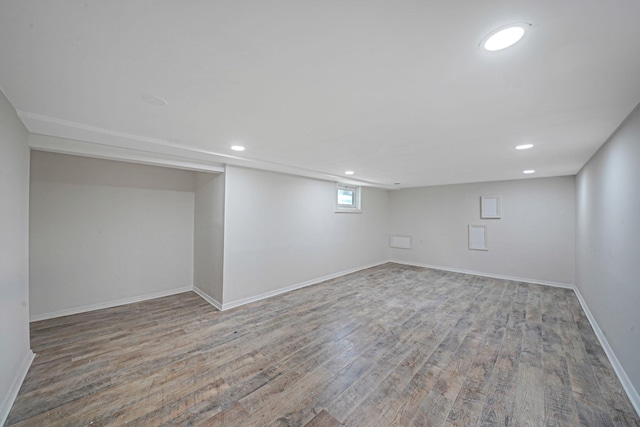 basement with baseboards, wood finished floors, and recessed lighting