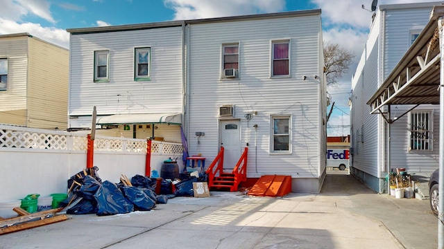 rear view of property with entry steps and fence