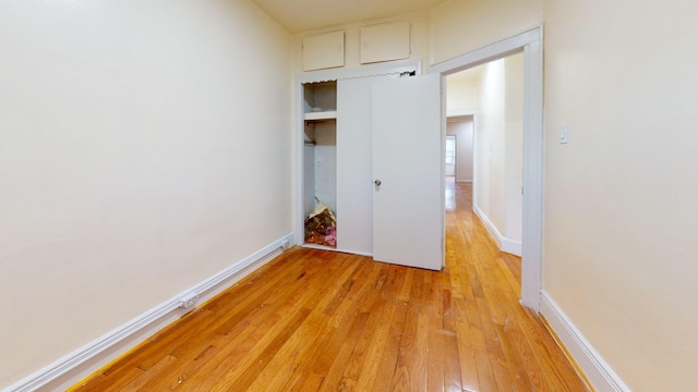 unfurnished bedroom with light wood-style flooring and baseboards