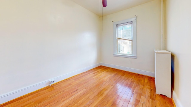 unfurnished room with light wood-style floors, baseboards, and a ceiling fan