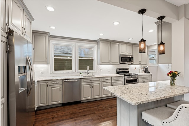 kitchen with a sink, stainless steel appliances, dark wood finished floors, and gray cabinets