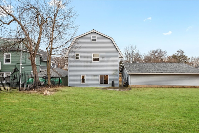 rear view of property with fence, a lawn, a gambrel roof, and roof with shingles