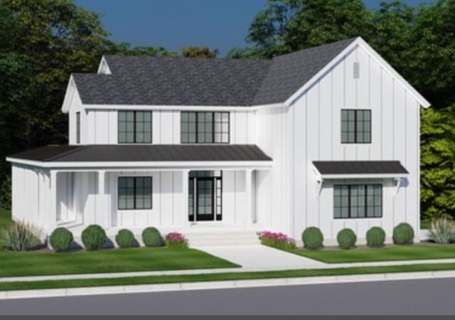 modern farmhouse style home featuring a standing seam roof, a front lawn, board and batten siding, and a porch