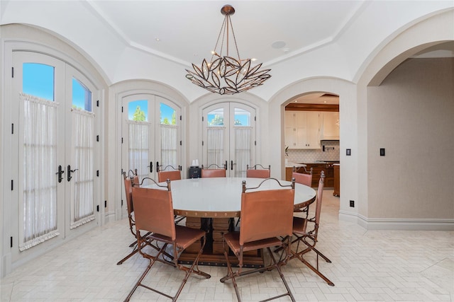 86 Gaylord Dr S, Brooklyn, NY 11234 - dining space featuring brick floor, arched walkways, french doors, and an inviting chandelier