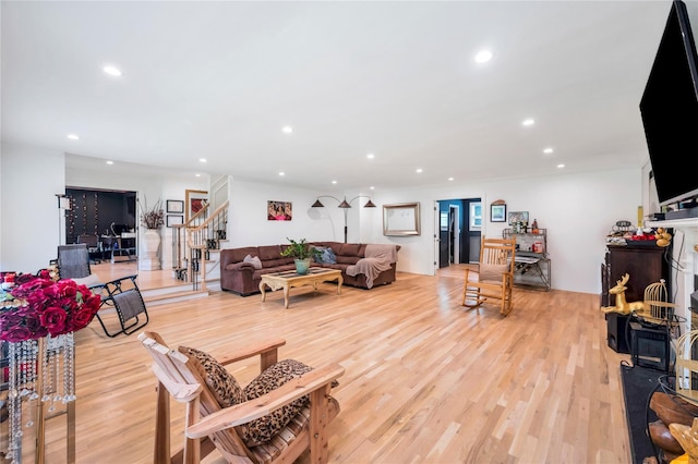 living area featuring light wood-style flooring, recessed lighting, and stairway