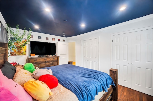 bedroom with ornamental molding, dark wood-type flooring, two closets, and recessed lighting