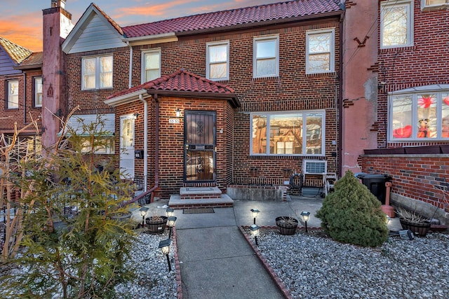 view of front of home featuring brick siding and a tile roof