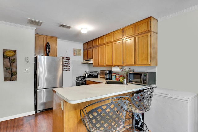 kitchen featuring under cabinet range hood, visible vents, stainless steel appliances, and a sink