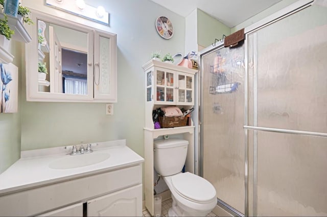 full bathroom featuring toilet, a stall shower, and vanity