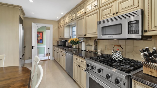 kitchen featuring cream cabinets, appliances with stainless steel finishes, backsplash, and recessed lighting