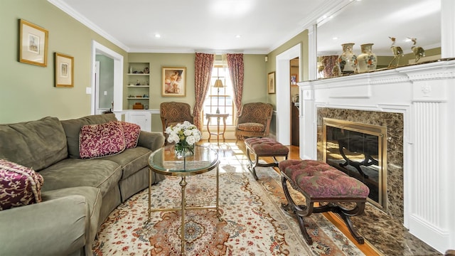 living room featuring a premium fireplace, built in features, and ornamental molding