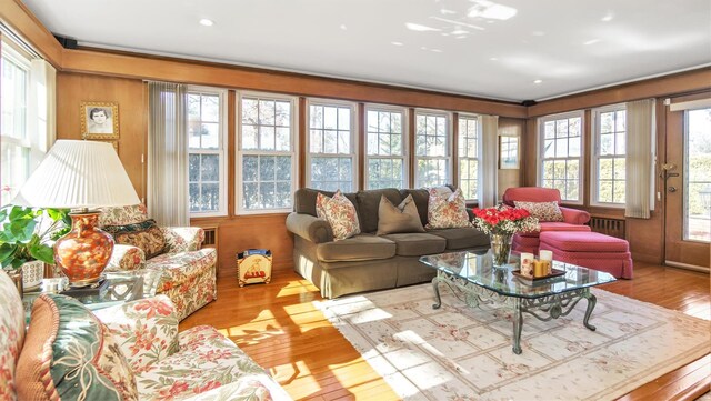 living room with hardwood / wood-style floors, radiator heating unit, plenty of natural light, and crown molding