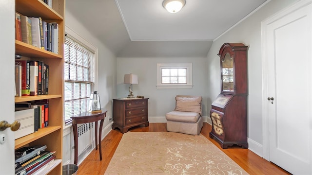 sitting room featuring vaulted ceiling, baseboards, and wood finished floors