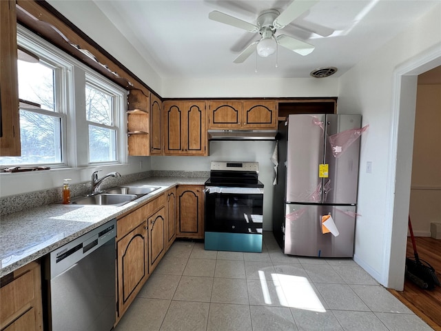 kitchen with visible vents, brown cabinets, stainless steel appliances, under cabinet range hood, and a sink