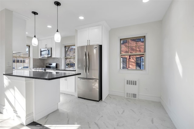 kitchen featuring marble finish floor, stainless steel appliances, dark countertops, and white cabinets