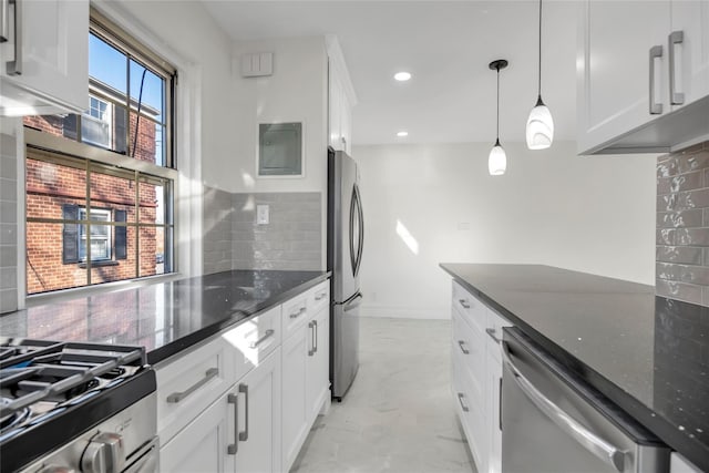 kitchen featuring stainless steel appliances, white cabinetry, marble finish floor, dark stone countertops, and pendant lighting