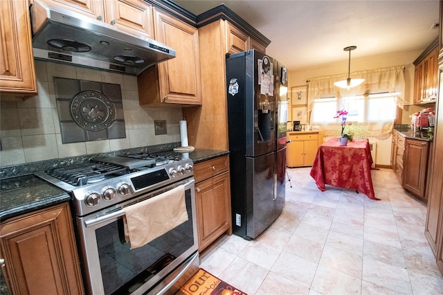 kitchen with tasteful backsplash, gas range, decorative light fixtures, freestanding refrigerator, and under cabinet range hood