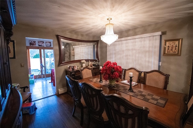 dining room featuring a notable chandelier, baseboard heating, and wood finished floors