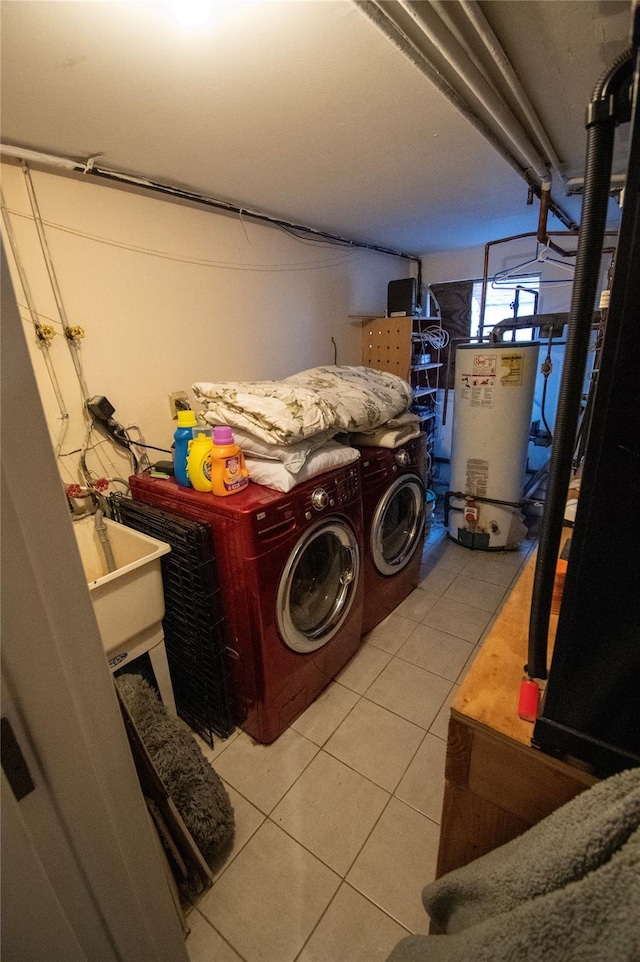 laundry area featuring light tile patterned floors, water heater, a sink, laundry area, and independent washer and dryer