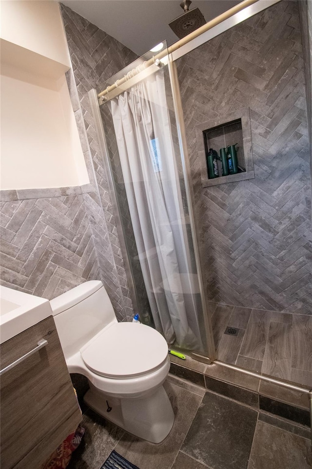 bathroom with toilet, a shower stall, and tile walls