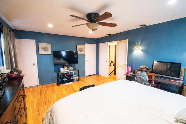 bedroom with visible vents, ceiling fan, and wood finished floors