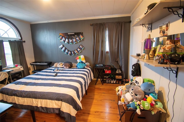 bedroom with crown molding and wood finished floors