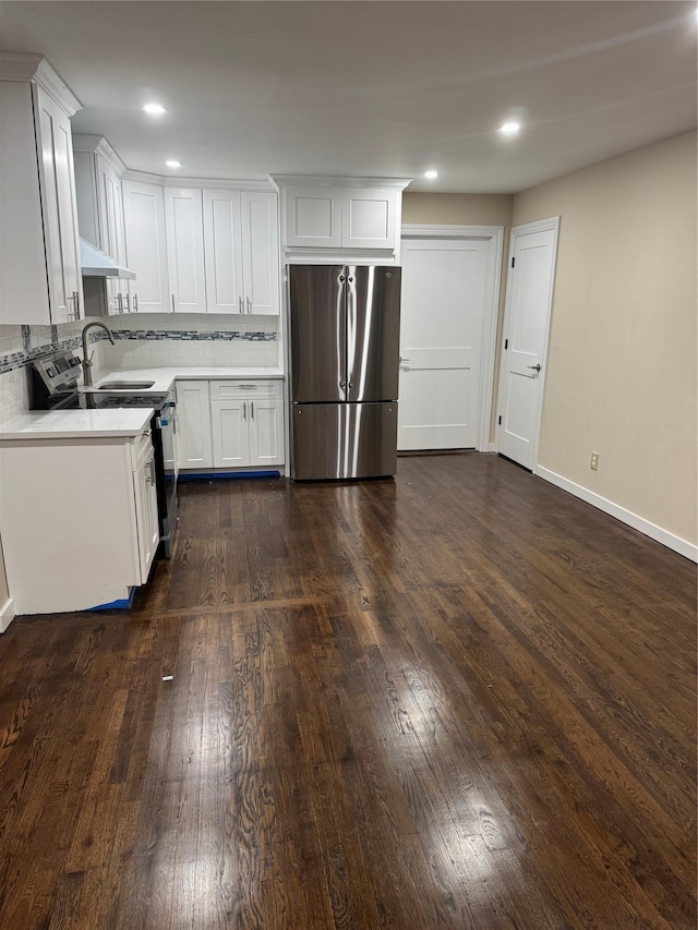 kitchen with stainless steel appliances, white cabinets, and dark wood-style floors