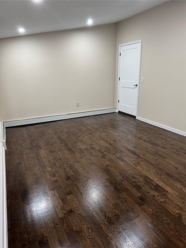 spare room with dark wood-style floors, baseboard heating, and baseboards