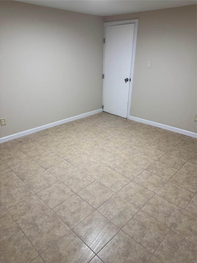 unfurnished room with baseboards