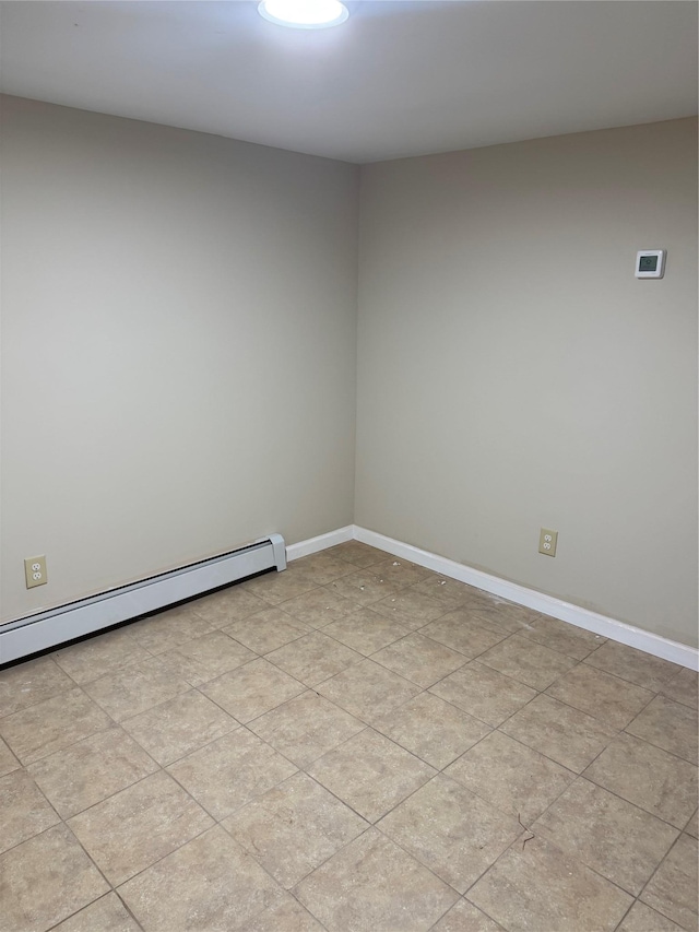 spare room featuring a baseboard heating unit and baseboards