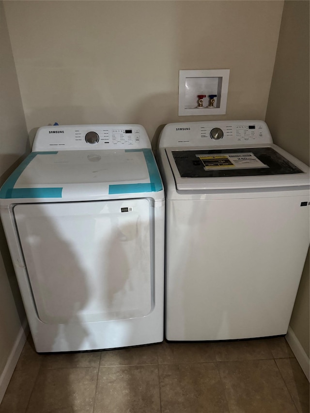 laundry area featuring laundry area, baseboards, washing machine and clothes dryer, and tile patterned floors