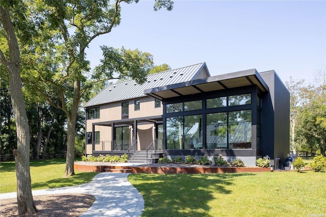 view of front of property featuring a standing seam roof, metal roof, and a front yard