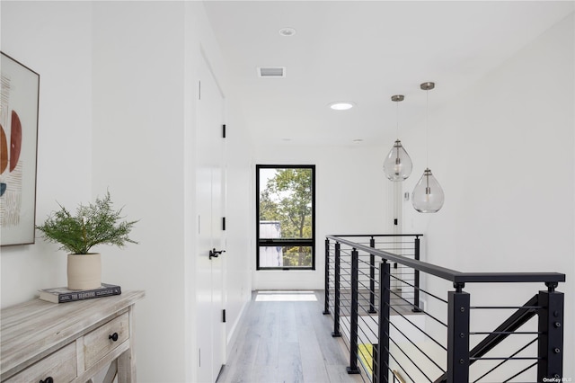 hall featuring recessed lighting, visible vents, light wood-style flooring, and an upstairs landing