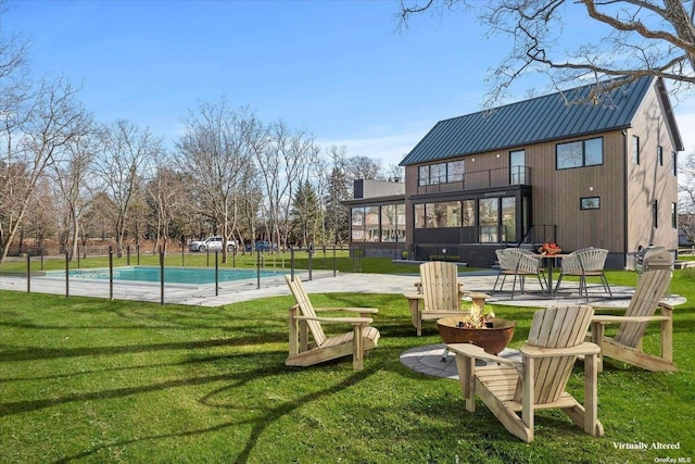 view of property's community featuring a yard, an outdoor fire pit, a patio area, and a pool