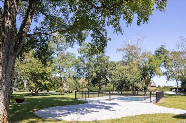 view of property's community featuring fence, a pool, a patio, and a yard