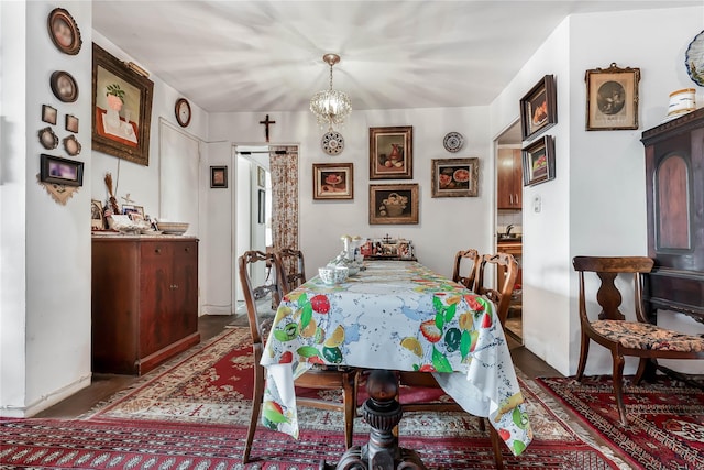 dining space with dark wood-style floors and a notable chandelier