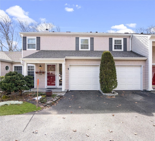 view of front facade featuring a garage, driveway, and a shingled roof