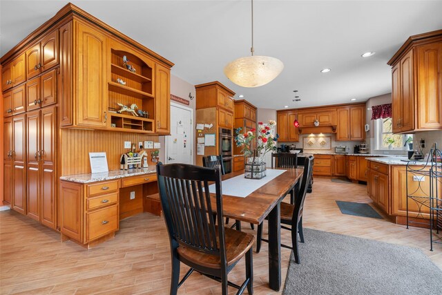 dining area with light wood-style floors, recessed lighting, and built in study area