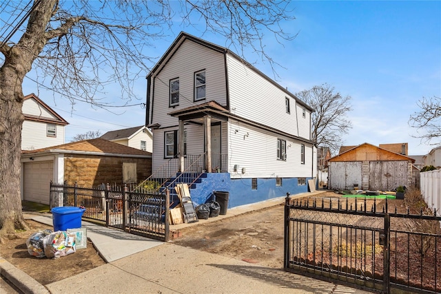 view of front facade with a fenced front yard, a gate, and an outdoor structure