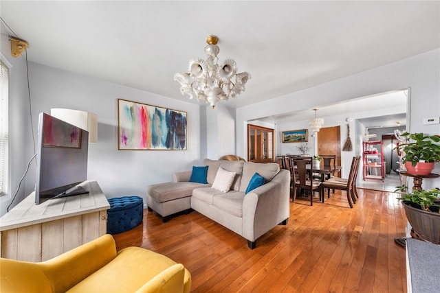 living room featuring hardwood / wood-style flooring and an inviting chandelier