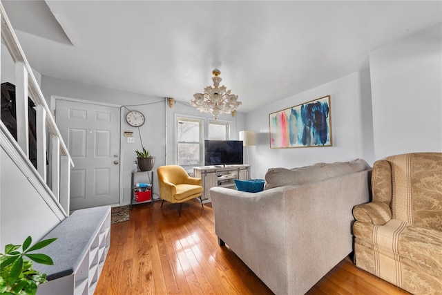 living room featuring stairs, a chandelier, and hardwood / wood-style floors